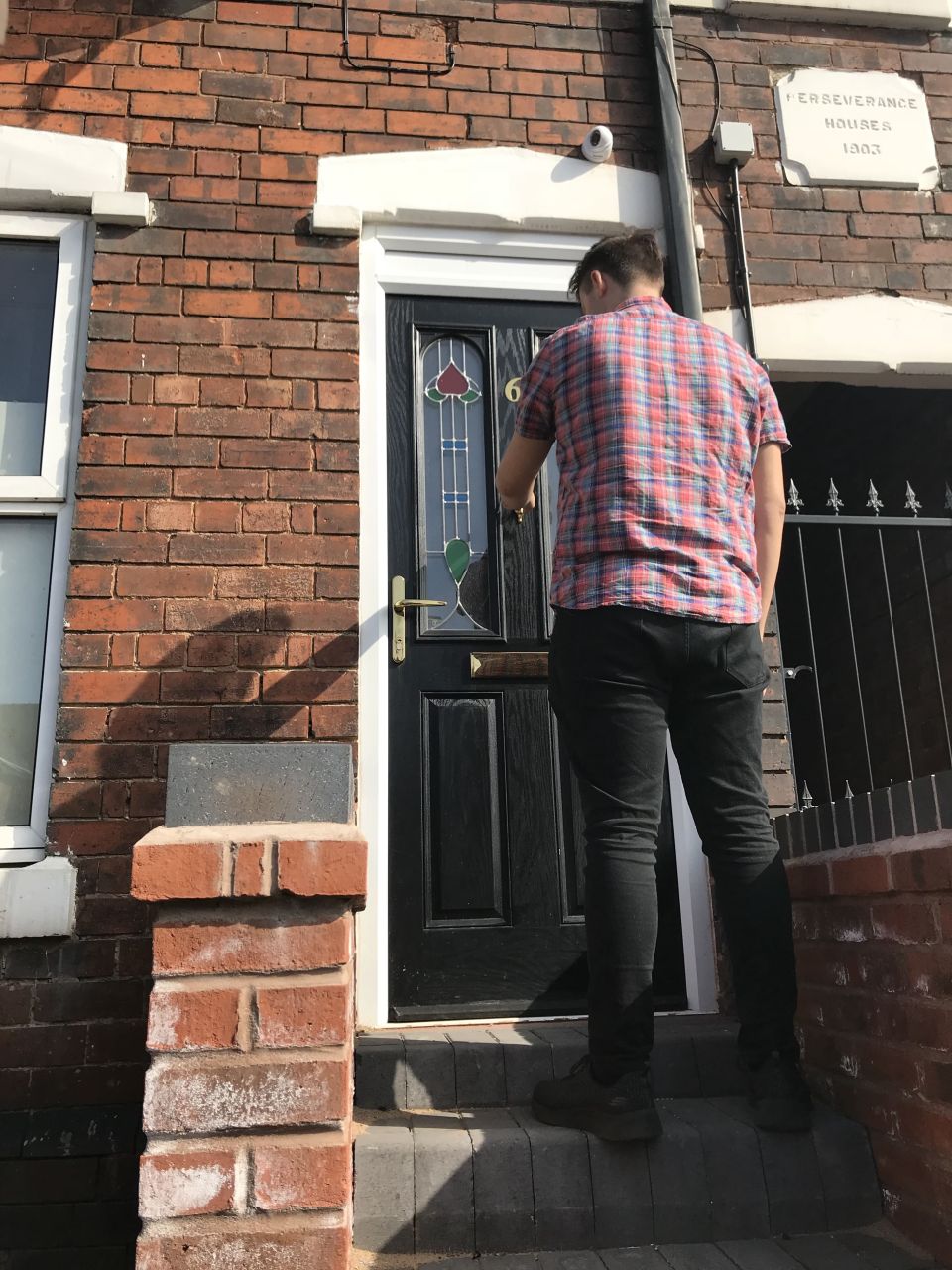 A man at the front door of Perseverance House, Ida Road