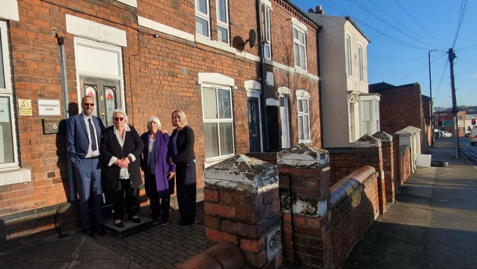 Four people standing outside Perseverance House on Ida Road
